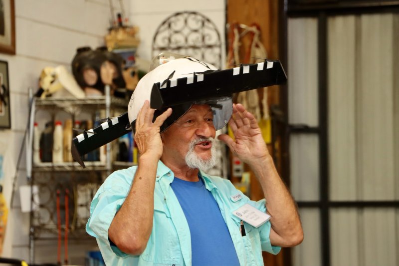 John Chirtea wears a hat in the shape of his electric flying car, called the Black Fly.